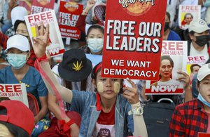 Anti-coup protesters display images of deposed Myanmar leader Aung San Suu Kyi in Yangon, Myanmar, Thursday, Feb. 25, 2021