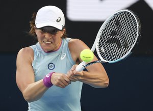 Poland's Iga Swiatek hits a backhand return to Romania's Simona Halep during their fourth round match at the Australian Open tennis championship in Melbourne, Australia, Sunday, Feb. 14, 2021.