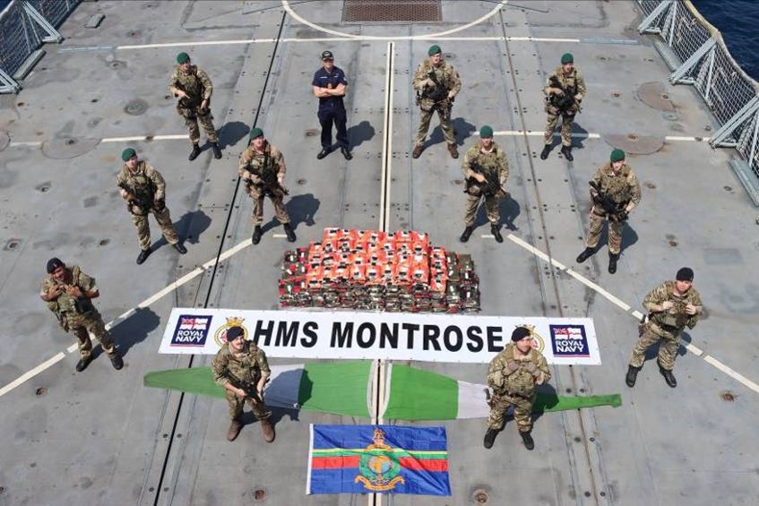 The boarding team from HMS Montrose, standing with the 450KG of methamphetamine seized during an operation in the Gulf