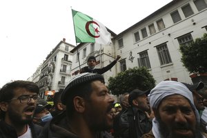 A man holds an Algerian flag while Algerians demonstrate to mark the second anniversary of the Hirak movement, Monday Feb. 22, 2021 in Algiers.