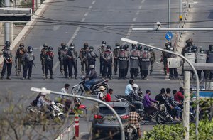 Police stand in formation blocking a main road in Mandalay, Myanmar, Saturday, Feb. 27, 2021.