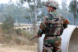 An Indian soldier takes position outside an army camp at Nagrota, in the outskirts of Jammu, India, Tuesday, Nov. 29, 2016.