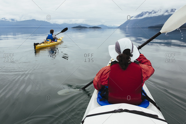 A small group of sea kayakers paddle pristine waters of Muir Inlet in Glacier Bay National Park, Alaska