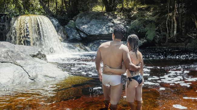 March 10, 2019: A young heterosexual Latin couple in love enjoying a pristine mountain stream in the Brazilian rainforest, Minas Gerais, Brazil, South America