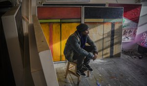 Painter Guy Stanley Philoche, a 43-year-old Haitian immigrant and star in the New York art world, sit among some of his latest work