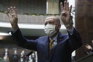 Turkey's President Recep Tayyip Erdogan gestures as he arrives to speak to his ruling party's lawmakers, in Ankara, Turkey