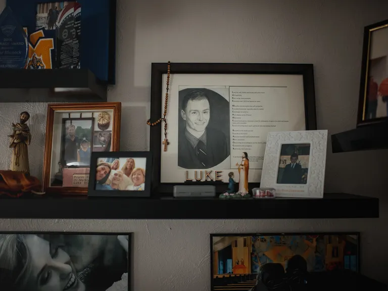 Portraits and various mementos of Luke Blanock sit on a shelf.