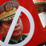 A protester holds a placard with the face of Myanmar’s commander in chief, Senior General Min Aung Hlaing during an anti-coup rally in front of the Myanmar Economic Bank in Mandalay.