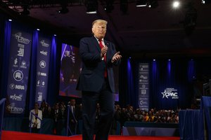 Donald Trump walks through a stage light as he arrives to speak at the CPAC at National Harbor, in Oxon Hill, Md., Saturday Feb. 29, 2020