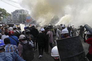 Anti-coup protesters discharge fire extinguishers to counter the impact of the tear gas fired by police during a demonstration in Mandalay, Myanmar, Sunday, March 7, 2021. The escalation of violence in Myanmar as authorities crack down on protests against the Feb. 1 coup is raising pressure for more sanctions against the junta, even as countries struggle over how to best sway military leaders inured to global condemnation. (AP Photo)