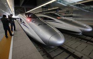 FILE - In this Oct. 26, 2010 file photo, a journalist photographs bullet trains of a new high-speed railway linking Shanghai and Hangzhou in Shanghai before the start of the service. In the annals of Chinese bureaucratic power, the Railways Ministry stood apart. Running everything from one of the world's busiest rail systems to a special police force, the ministry was so pervasive and powerful it resisted government reform efforts for years. Chinese called it