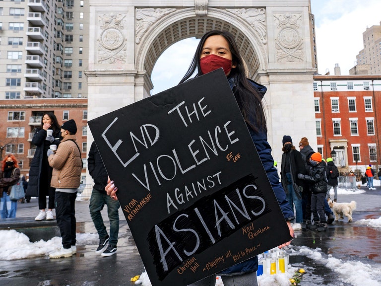 A person holding a sign that reads End the Violence Against Asians in Washington Square Park 