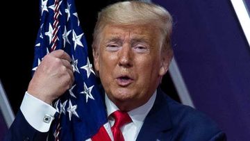 Donald Trump cuddles a flag at last year&#x27;s CPAC.