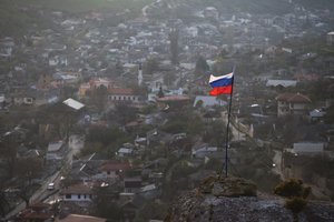 In this March 28, 2014 file photo, a Russian national flag flies on a hilltop near the city of Bakhchysarai, Crimea.