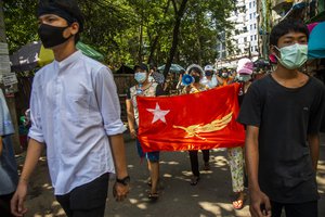 Protesters chant slogans and march in the street of Myaynigone township during the anti-coup demonstration in Yangon, Myanmar, Friday, April 9, 2021