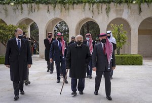 This photo from the Royal Court twitter account, shows Jordan’s King Abdullah II, second right, Prince Hamzah bin Al Hussein, fourth right in blue mask, Prince Hassan bin Talal, fifth right, and others arriving to visit the tombs of former kings, in Amman, Jordan, Sunday, April 11, 2021