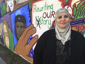 In this Wednesday, Feb, 1, 2017 photo, activist Samia Assed in stands in front of a mural at the Albuquerque Center for Peace and Justice coalition in Albuquerque. Assed, 51, a Palestinian-American, has now turned her fears over Donald Trumps election into action, joining what advocacy groups say are hundreds, possibly thousands of women of color, who are exploring making a run for public office.  (AP Photo/Russell Contreras)