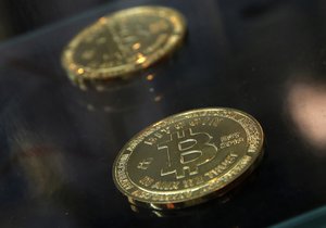 In this Dec. 8, 2017, file photo, coins are displayed next to a Bitcoin ATM in Hong Kong.