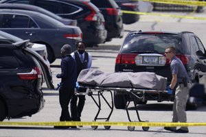 A body is taken from the scene where multiple people were shot at a FedEx Ground facility in Indianapolis, Friday, April 16, 2021