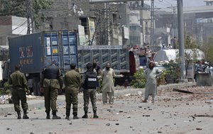 Supporters of Tehreek-e-Labiak Pakistan, a banned Islamist party, block a road and talk with police officers, during a protest over the arrest of their party leader Saad Rizvi, in Lahore, Pakistan, Sunday, April 18, 2021.