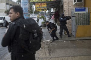 In this June 21, 2017 photo, police fight drug traffickers in the City of God slum in Rio de Janeiro, Brazil.