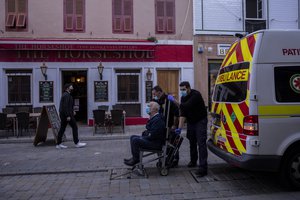 Two health workers transport an elderly patient, in Gibraltar, Thursday, March 4, 2021. Gibraltar, a densely populated narrow peninsula at the mouth of the Mediterranean Sea, is emerging from a two-month lockdown with the help of a successful vaccination rollout.