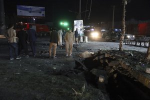 Security personnel inspect the site of a bomb attack in Kabul, Afghanistan, Wednesday, April 21, 2021.