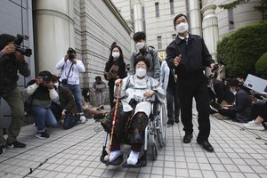 Former South Korean comfort woman Lee Yong-soo in a wheelchair leaves the Seoul Central District Court in Seoul, South Korea, Wednesday, April 21, 2021.