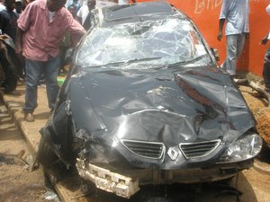 A man inspects a crashed car that was involved in a gruesome accident which resulted in the loss of four human lives in Freetown.