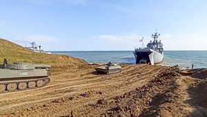 This handout photo taken from a video released on Friday, April 23, 2021 by Russian Defense Ministry Press Service shows, Russian military's armored vehicles roll into landing vessels after drills in Crimea.