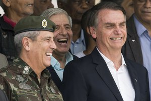 FILE - In this Nov. 24, 2018 file photo, Brazil's President-elect Jair Bolsonaro, right, and Gen. Walter Souza Braga Netto, smile during a ceremony marking the 73 rd anniversary of the Brazilian Paratrooper Infantry Brigade in Rio de Janeiro, Brazil.