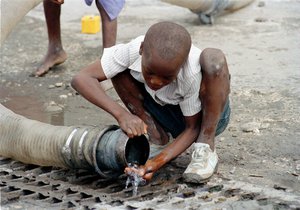 File - Only 1.5 per cent of the population of Haiti has piped water supply. A mere 29 percent have ready access to drinking water. A young boy getting a drink of water from an open pipe on the streets of Port-au-Prince.