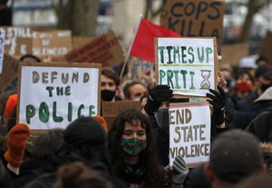 File - Demonstrators hold up placards as they gather outside New Scotland Yard in London, Sunday, March 14, 2021 during a protest over the abduction and murder of Sarah Everard and the subsequent handling by the police of a vigil honoring the victim.