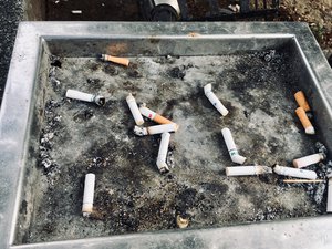 Bent and used cigarette butts in an ash tray. Taken on October 2018.