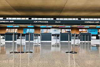 Empty aisles and stations at the check-in counter at an airport.