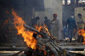 Multiple funeral pyres of COVID-19 victims burn as relatives perform last rites at a crematorium in New Delhi, India, Friday, April 30, 2021.