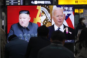 File - Commuters watch a TV showing a file image of North Korean leader Kim Jong Un and U.S. President Joe Biden during a news program at the Suseo Railway Station in Seoul, South Korea, Friday. March 26, 2021.