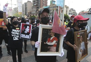 Myanmar nationals living in Taiwan hold Aung San Suu Kyi's portrait to express their disdain towards the military regime in Myanmar during a demonstration in Taipei, Taiwan, Sunday, May 2, 2021.