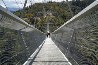 People walk across a narrow footbridge suspended across a river canyon, which claims to be the world’s longest pedestrian bridge, in Arouca, Portugal. 