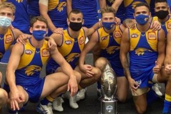 Eagles players, three of them using a controversial hand gesture, pose for a team photo.