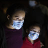 Fatima Nayeli, 13, left, and her sister, Cynthia Stacy, 8, answer questions from a US Border Patrol agent at an intake site after they were smuggled on an inflatable raft across the Rio Grande in Roma, Texas.