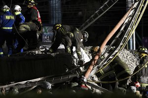 Rescue personnel retrieve bodies from the scene of an accident where subway cars fell after a section of Line 12 of the subway collapsed in Mexico City, Tuesday, May 4, 2021.