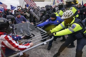 In this Jan. 6, 2021, file photo, Trump supporters try to break through a police barrier at the Capitol in Washington.