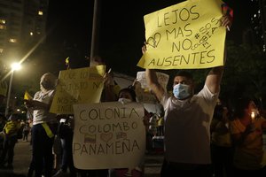 Colombians living in Panama hold signs as gather during vigil in Panama City, Wednesday, May 5, 2021