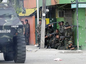 Government troopers fire their weapons as they continue their assault on Muslim rebels Thursday, Sept. 12, 2013, in Zamboanga city in the southern Philippines.