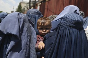 In this June 3, 2019 file photo, Afghan women wait to receive free food donated by Muslim Hands, a not-for-profit organization, in Kabul, Afghanistan. As US forces withdraw from Afghanistan many Afghans fear the Taliban will reassert their authority.