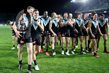 Tom Jonas, Karl Amon and Port players walk off with the Showdown Trophy after beating Adelaide on Saturday night.