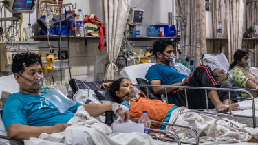 Patients who contracted the coronavirus lie in beds while connected to oxygen supplies in a  hospital in New Delhi.