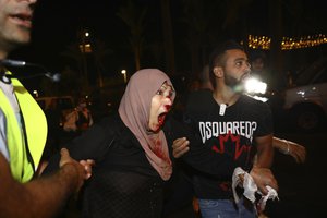 An injured female Palestinian demonstrator is helped during a protest against the planned evictions of Palestinian families in the Sheikh Jarrah neighborhood of east Jerusalem, Saturday, May 8, 2021.