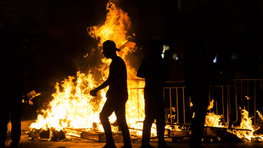 Palestinians stand next to a burning barricade during clashes with Israeli police officers during the holy month of Ramadan on May 8, 2021 in Jerusalem, Israel. Tensions continue in Jerusalem’s Old City after clashes in Al-Aqsa Mosque where dozens of Palestinians were seriously injured. 